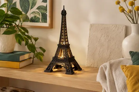 Maquette en bois noir de la Tour Eiffel assemblée, posée sur une étagère et éclairée par ses LED.