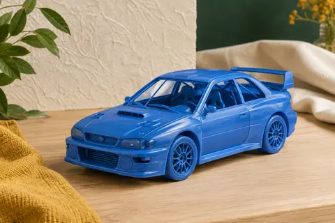 Maquette en plastique non peinte de la Subaru Impreza WRC 99 à l’échelle 1:24 sur une table en bois clair.